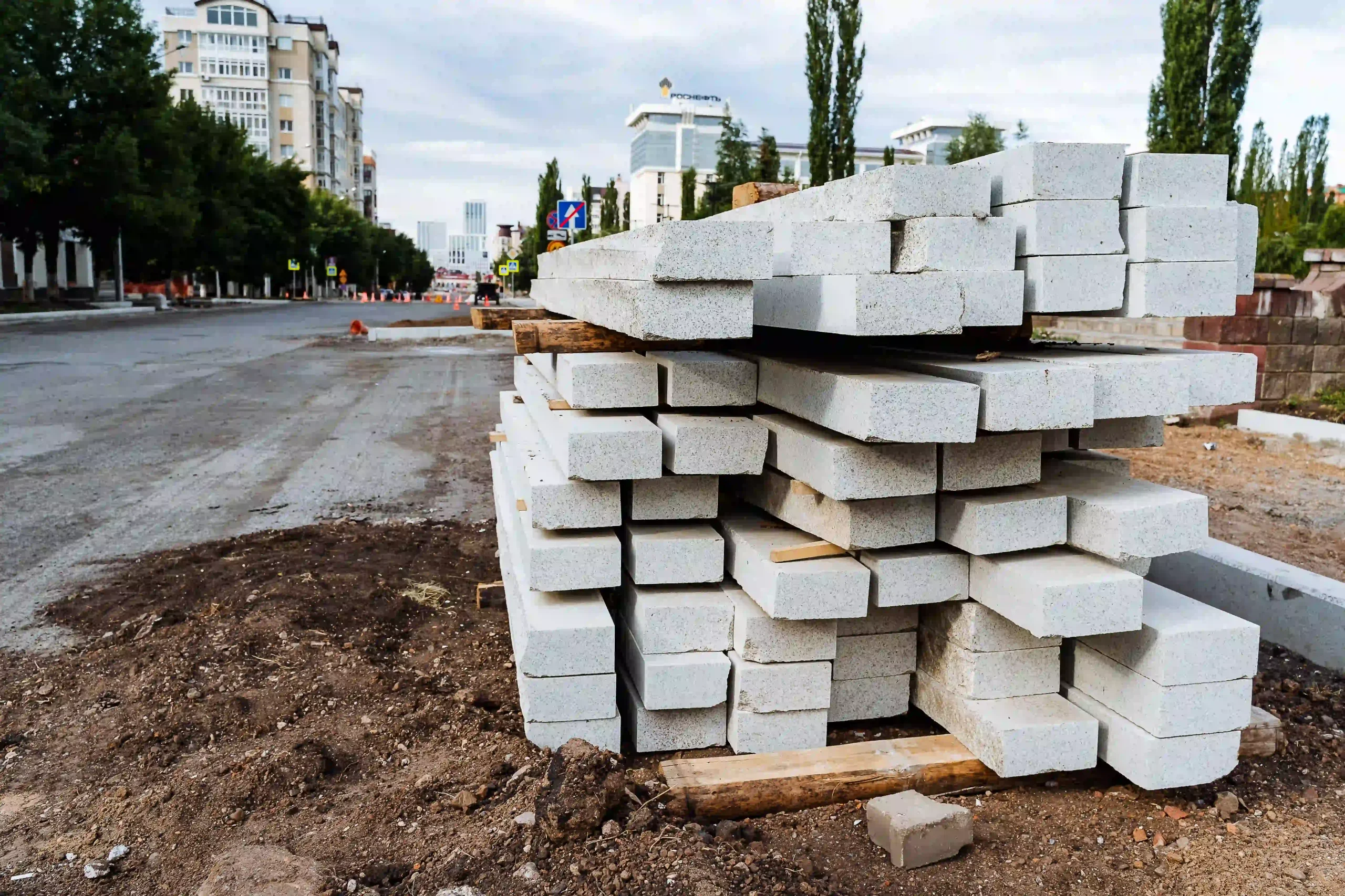 white concrete blocks for paving slabs are stacked on the street a curb for a pedestrian path free photo